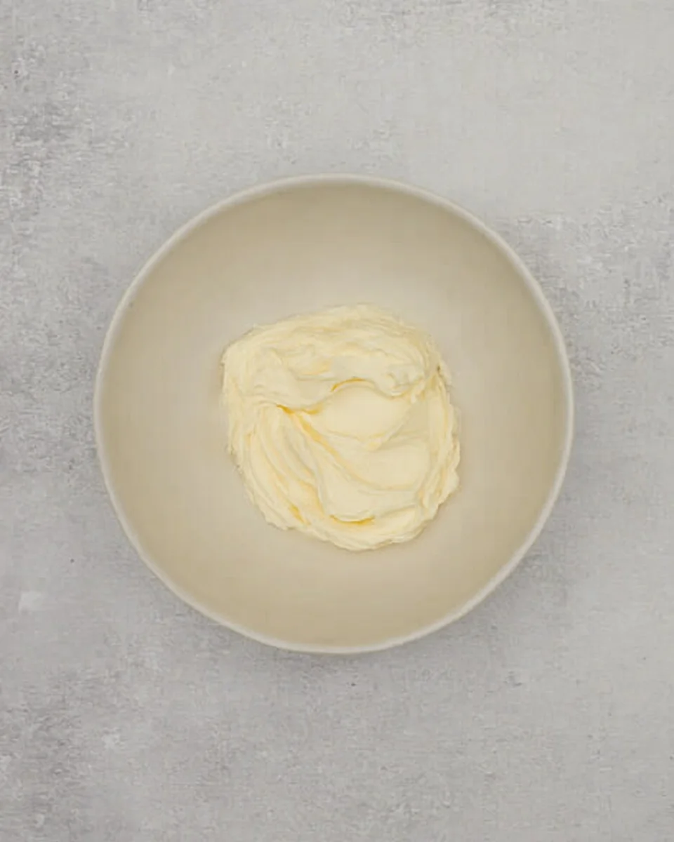 Cream cheese beaten in a bowl.