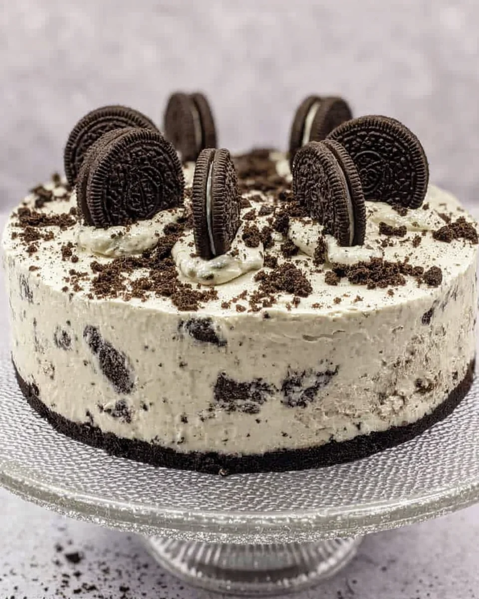 A homemade Oreo cheesecake, on a cake stand.