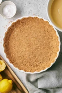 Graham cracker crust in a ceramic pie dish.