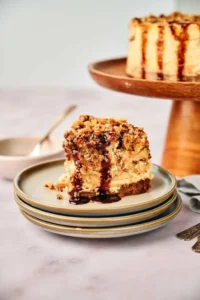 A slice of apple pie stuffed cheesecake is sitting on a plate.