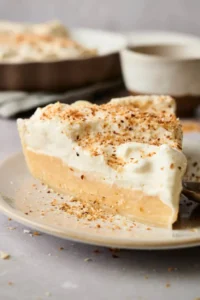 A slice of coconut cream pie on a plate.