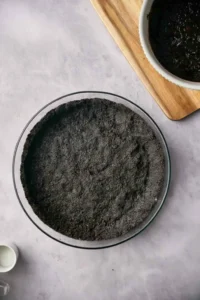 Chocolate Oreo crust in a pie dish.