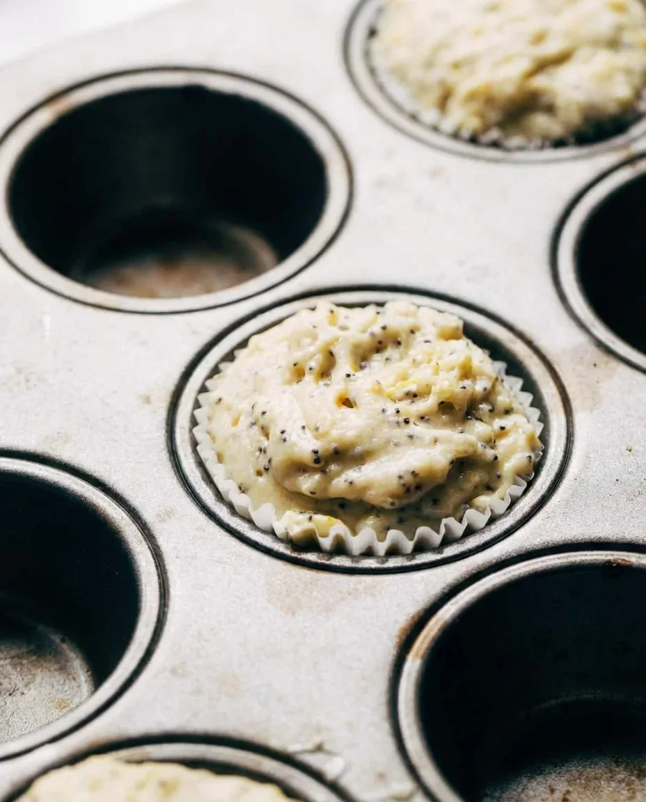 Freshly baked lemon poppy seed muffins with shiny lemon syrup glaze.