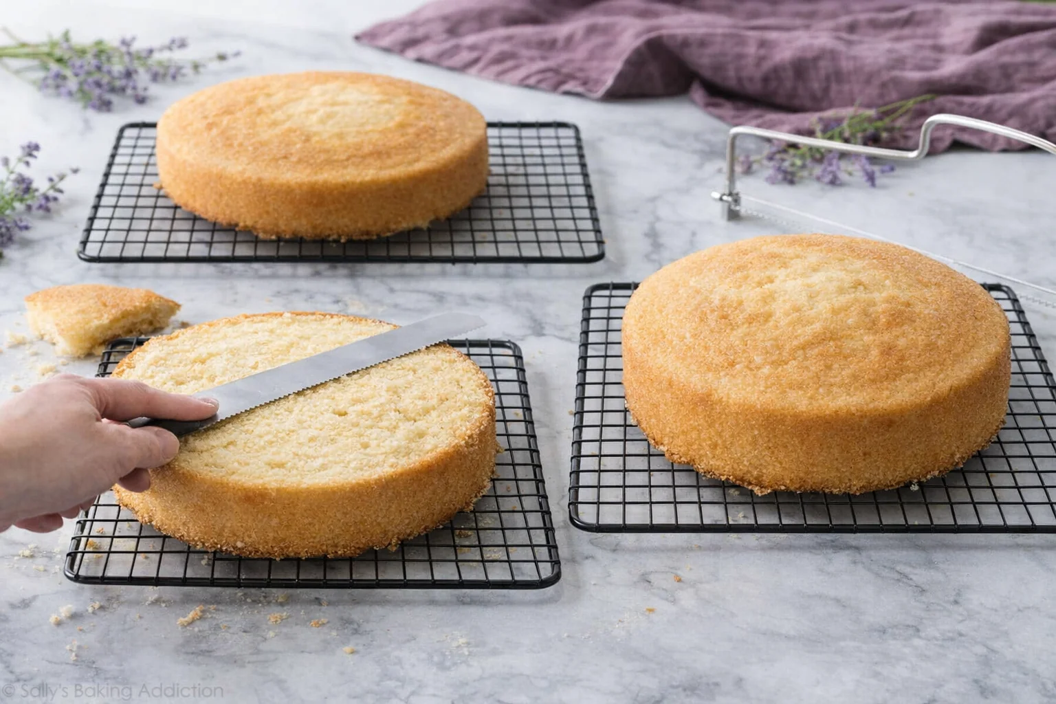 step-process-placeholder-9-10.png Cooling cake layers on wire racks, and slicing off domed tops with serrated knife