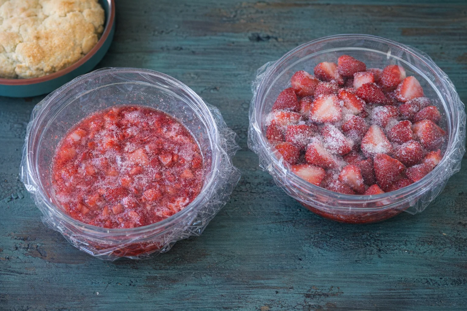 step-process-placeholder-7-8.png Two bowls of strawberries: one crushed with sugar and one whole sugared, both covered.