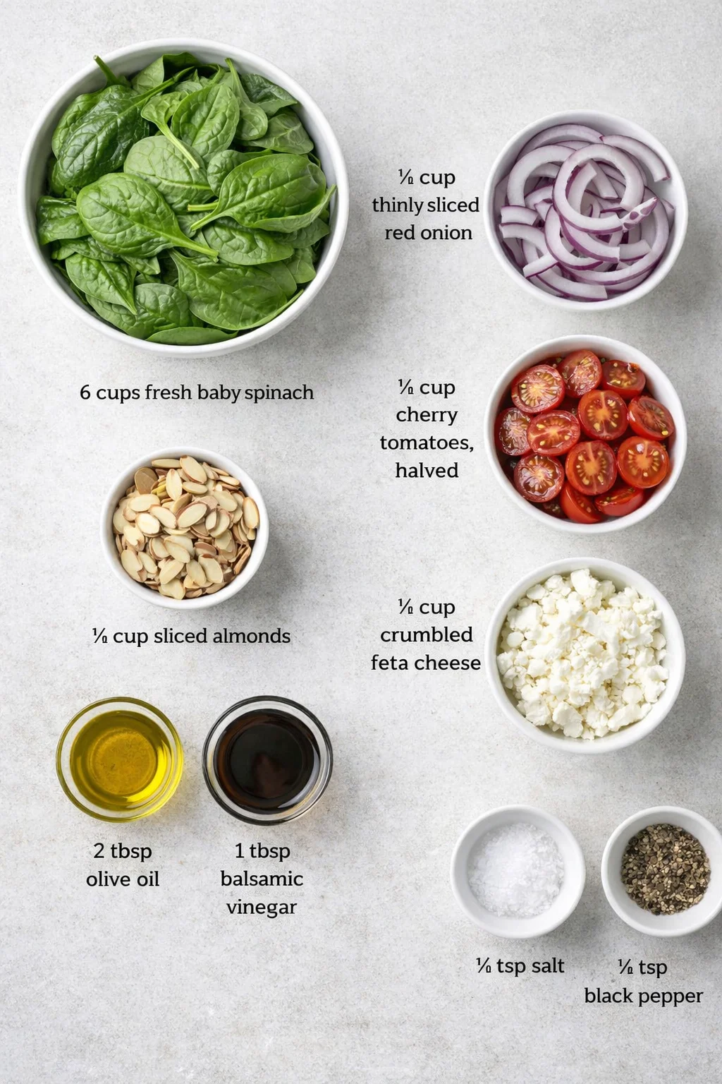 Top-down collage of bowls showing spinach, red onion, cherry tomatoes, almonds, feta, olive oil, and balsamic vinegar.