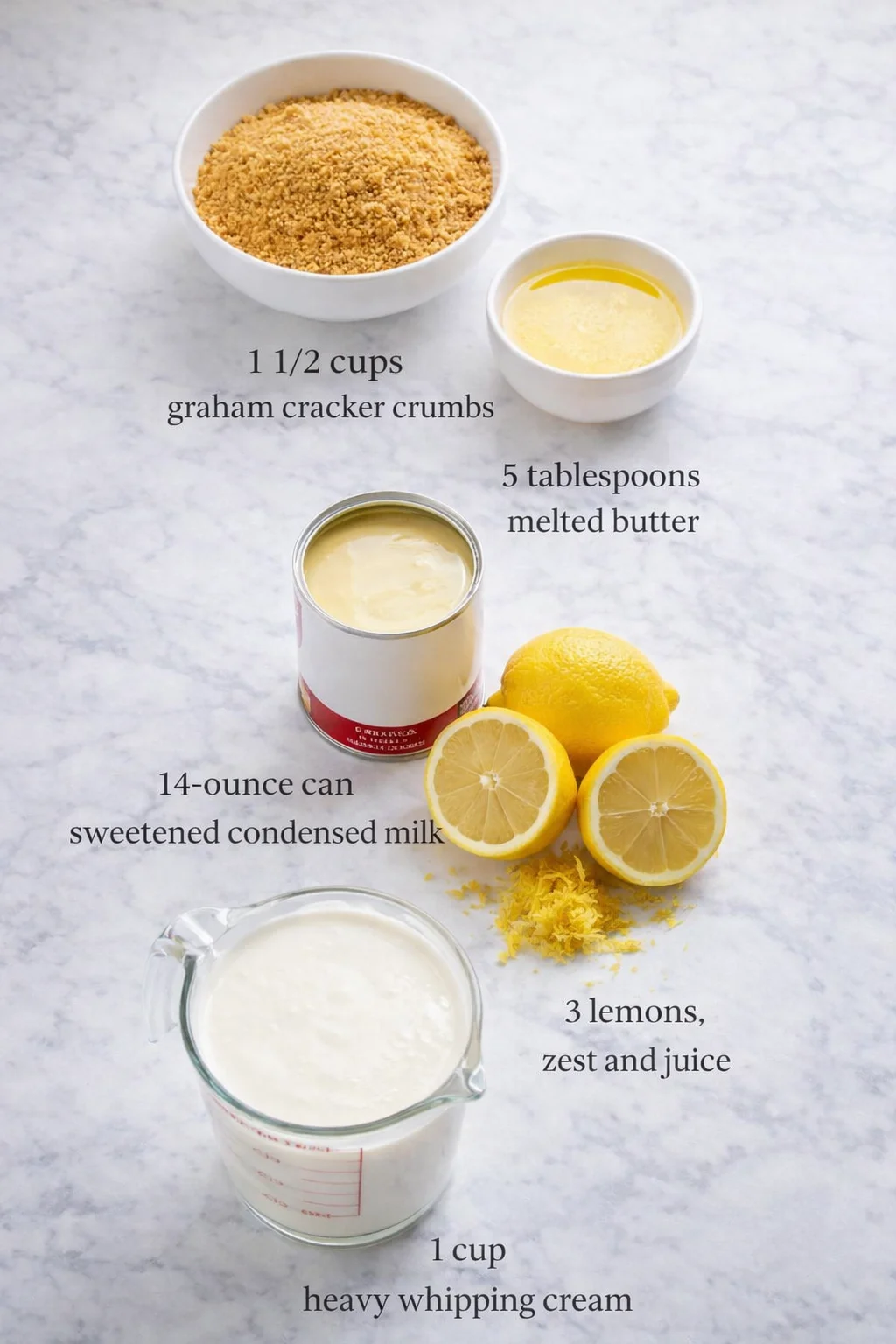 Measured ingredients arranged for No Bake Lemon Tart: 1 1/2 cups graham cracker crumbs, 5 tablespoons melted butter, 14-ounce can of sweetened condensed milk about 400 grams, 3 lemons, zest and juice, 1 cup heavy whippin