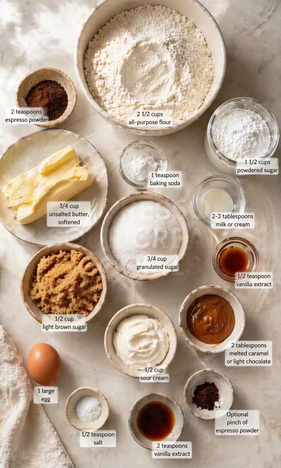 overhead view of baking ingredients arranged in bowls on a marble surface