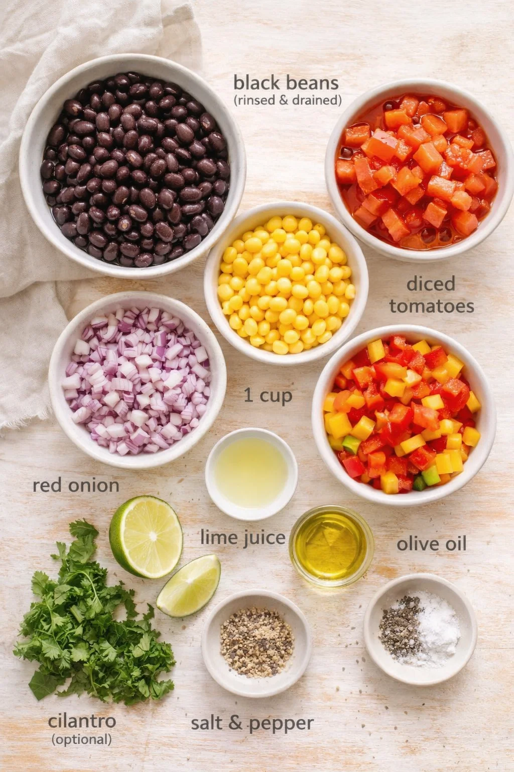 top-down view of bowls with black beans, corn, diced tomatoes, red onion, lime, cilantro, olive oil, and seasonings.