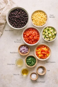 top-down view of bowls containing black beans, corn, diced tomatoes, avocado, red onion, peppers, and cilantro
