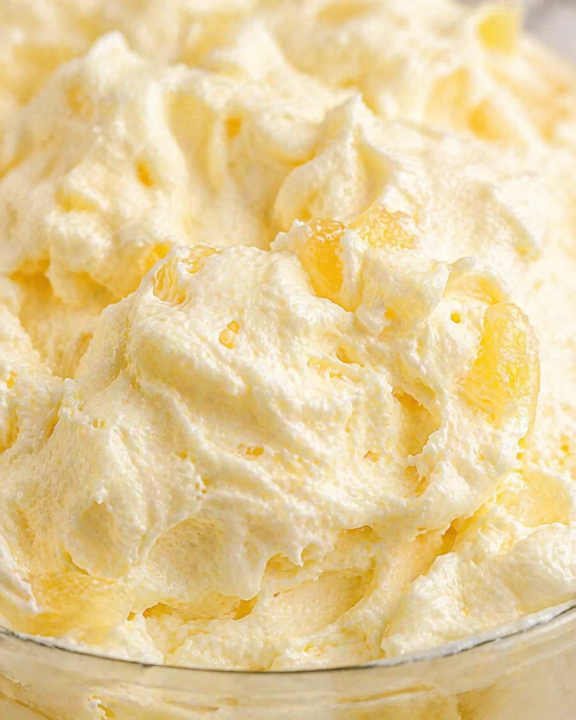 Close-up of fluffy mashed potatoes with buttery yellow specks in a glass bowl