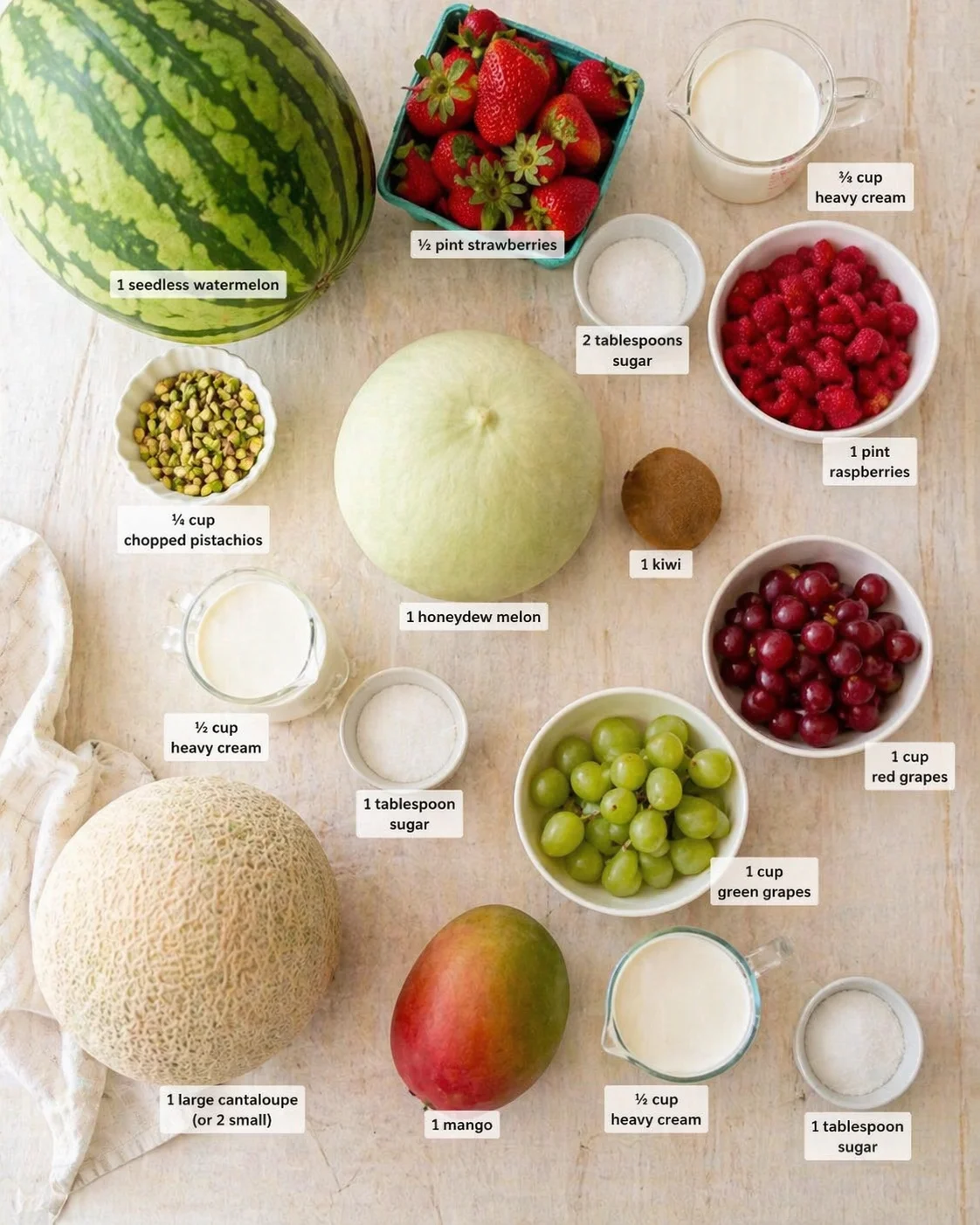 Overhead view of assorted fresh fruits, nuts, and dairy labeled for a recipe.