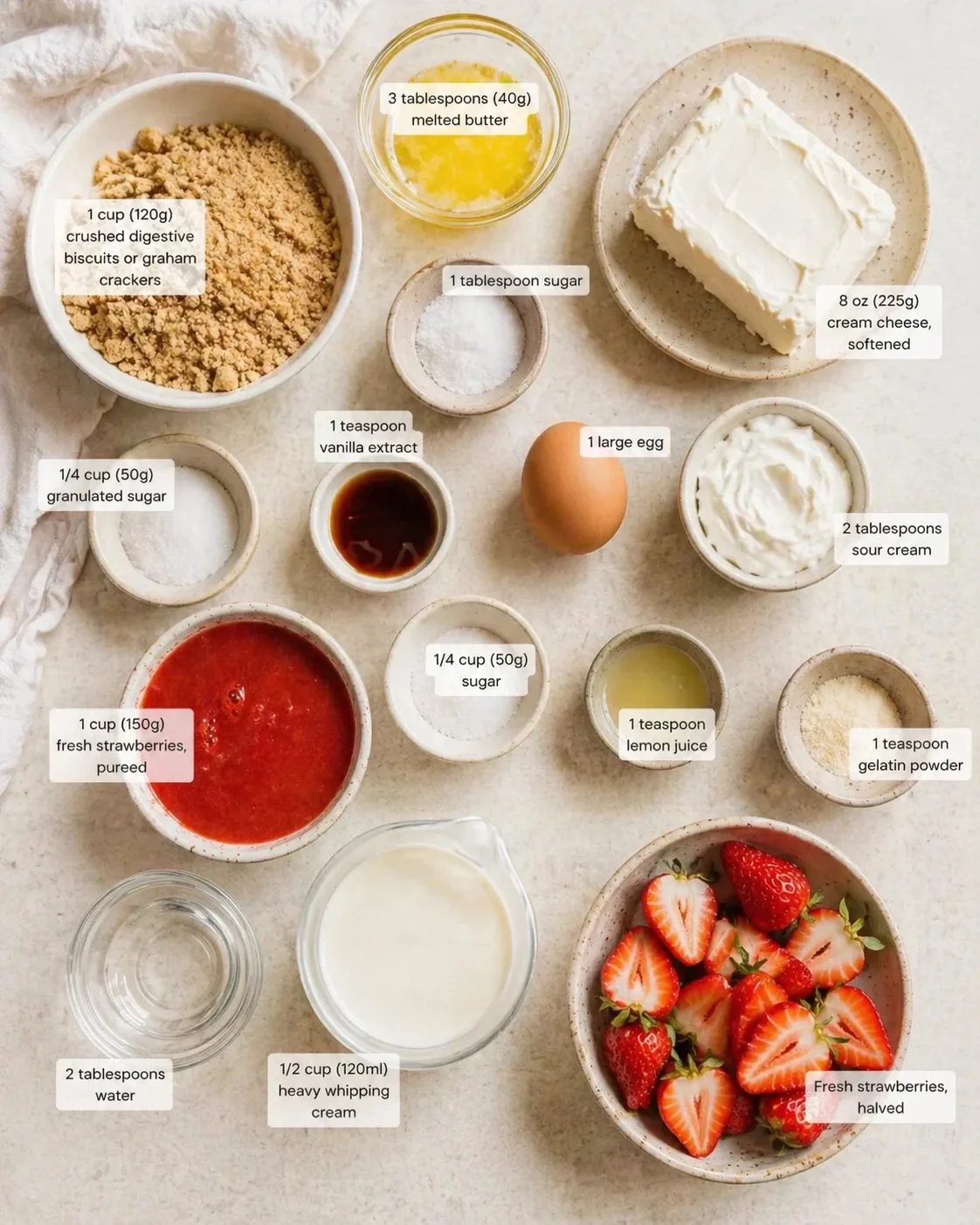strawberry-cheesecake-ingredients-layout Overhead view of ingredients for strawberry cheesecake arranged in bowls with labeled measurements.