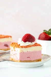 Slice of strawberry shortcake ice cream cake with whipped cream and a strawberry on top