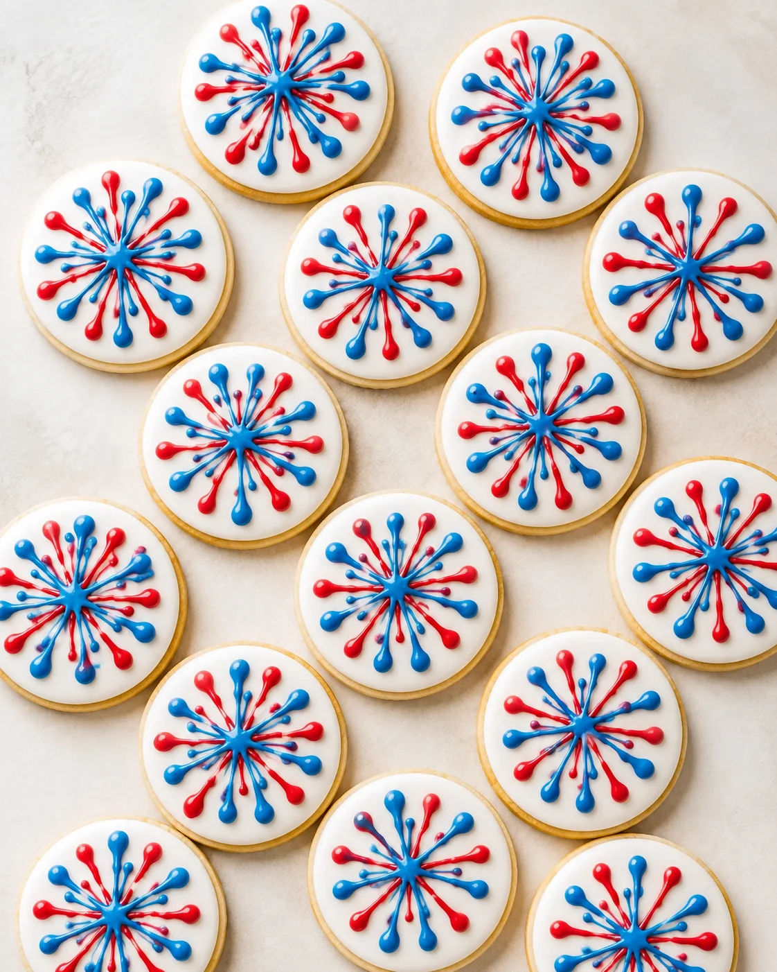 round sugar cookies with white icing and red-blue starburst designs on a light background