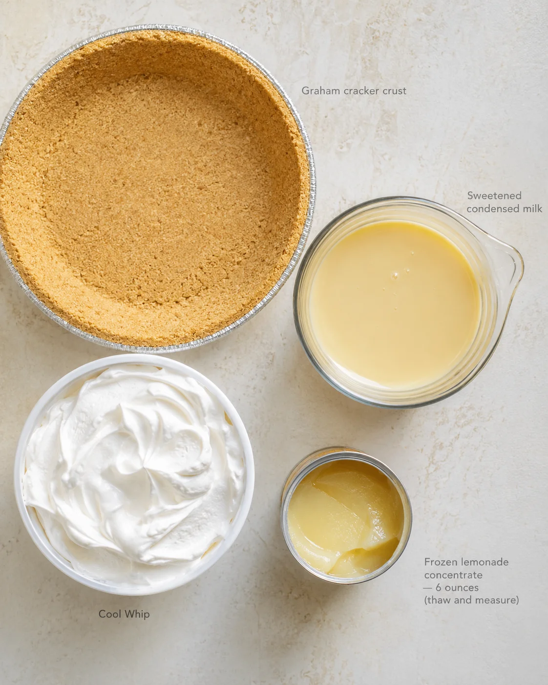 overhead view of graham crust, condensed milk, whipped topping, and lemonade concentrate for lemon pie