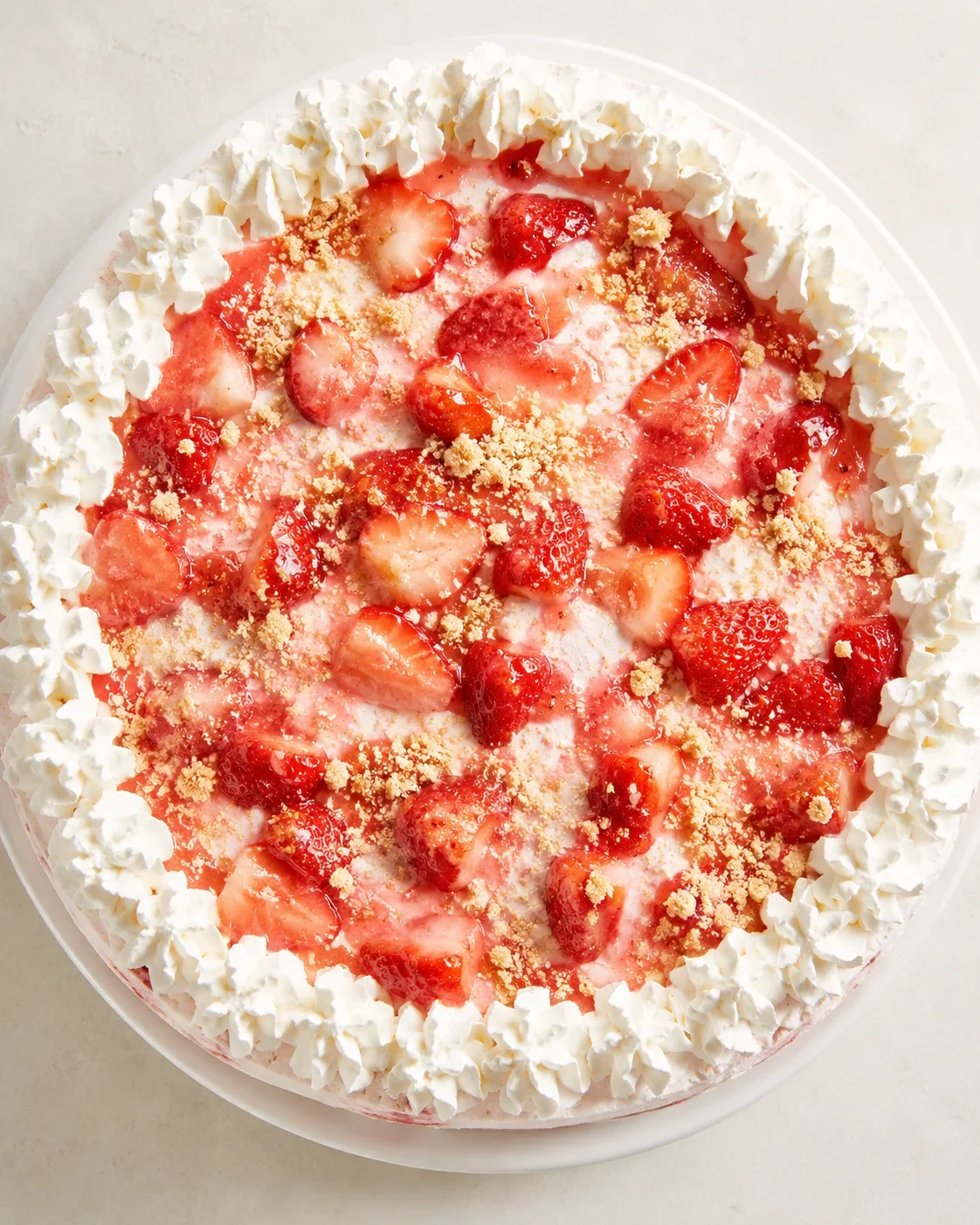 Delicious homemade strawberry shortcake ice cream cake topped with strawberries and whipped cream.