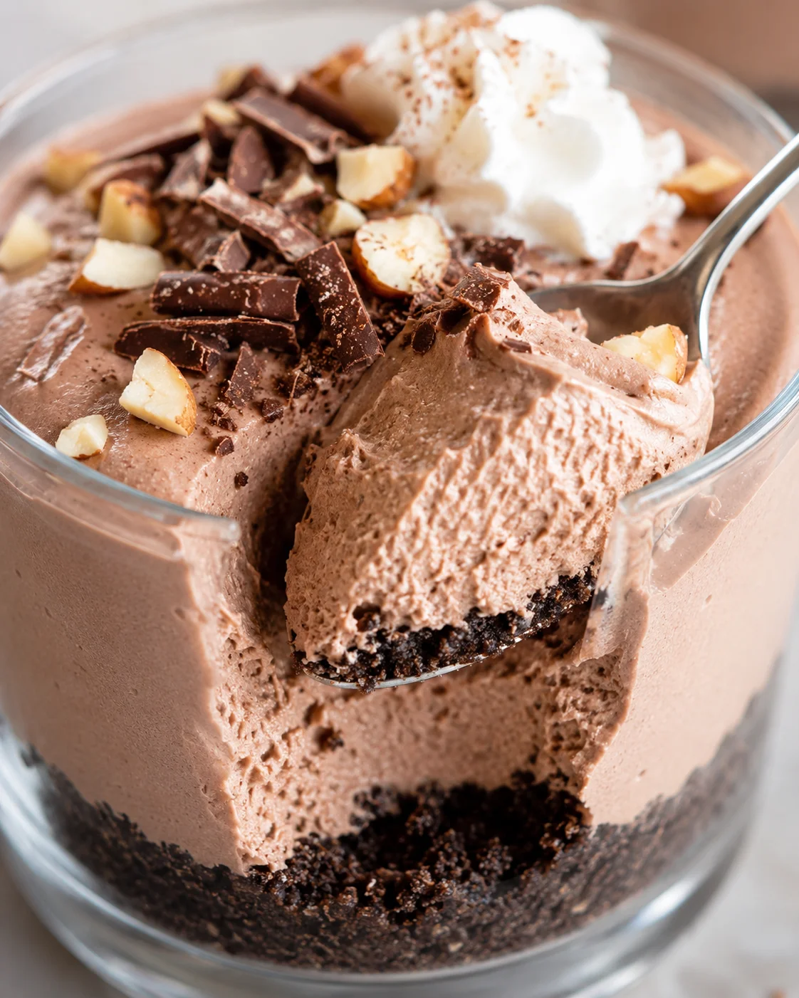 Creamy chocolate hazelnut dessert topped with whipped cream and chopped hazelnuts