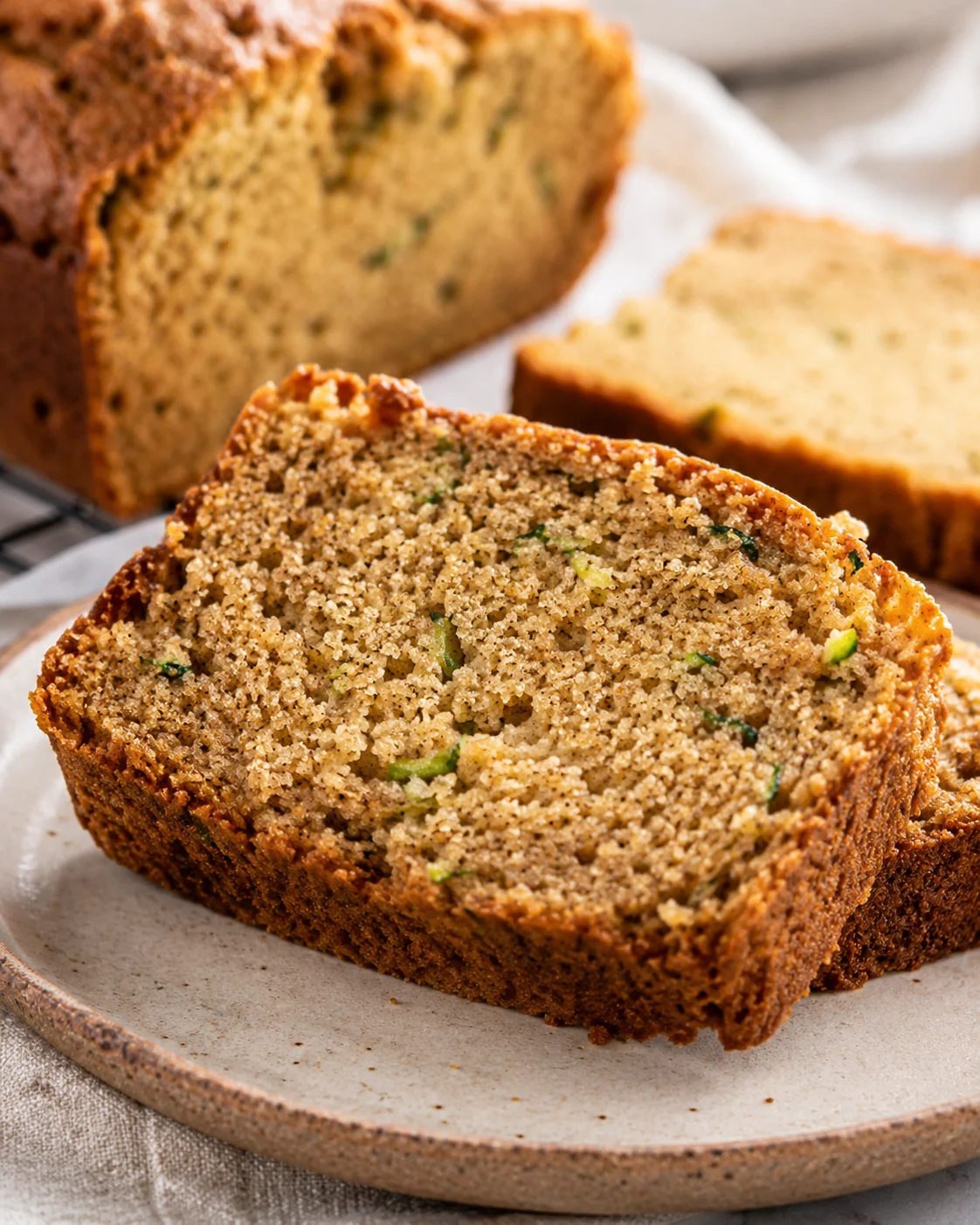 Close-up of moist and spiced zucchini bread slices on a plate.