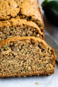 One loaf of zucchini bread with half cut into bread slices