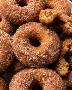 Close-up of golden baked apple cider donuts with cinnamon sugar coating.