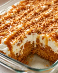 Delicious pumpkin cake topped with caramel drizzle, Cool Whip, and crunchy Heath bits.