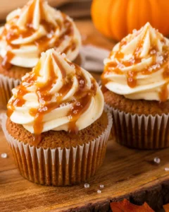 Close-up of moist pumpkin cupcakes topped with salted caramel cream cheese frosting and caramel drizzle