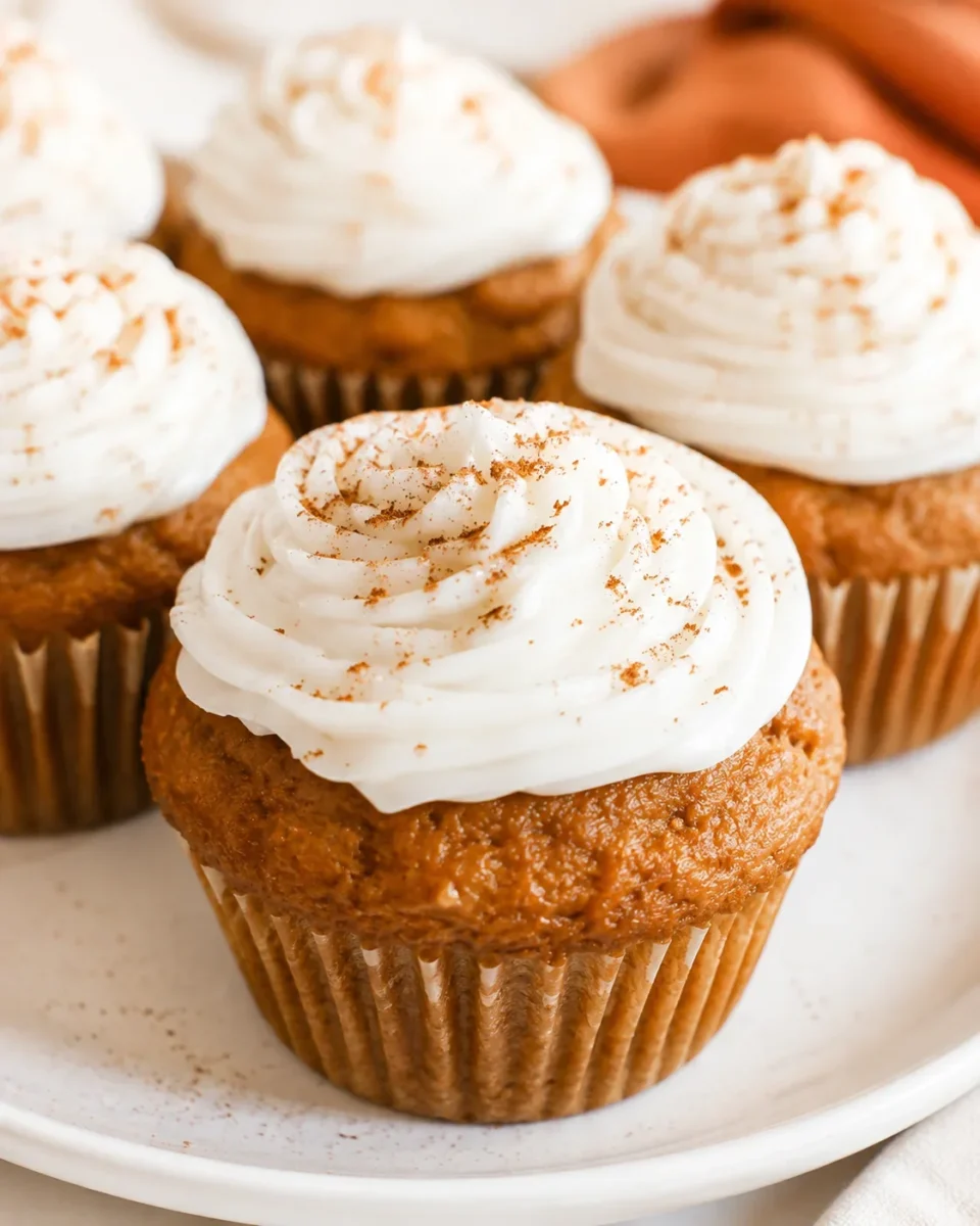 Close-up of moist, fluffy pumpkin cupcakes with dairy-free cream cheese frosting.