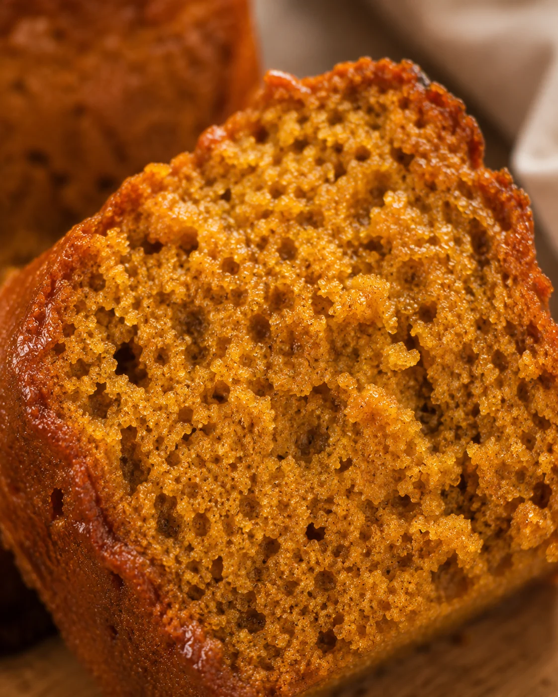 Close-up of a sliced, moist, spiced pumpkin bread loaf with a warm, inviting texture.