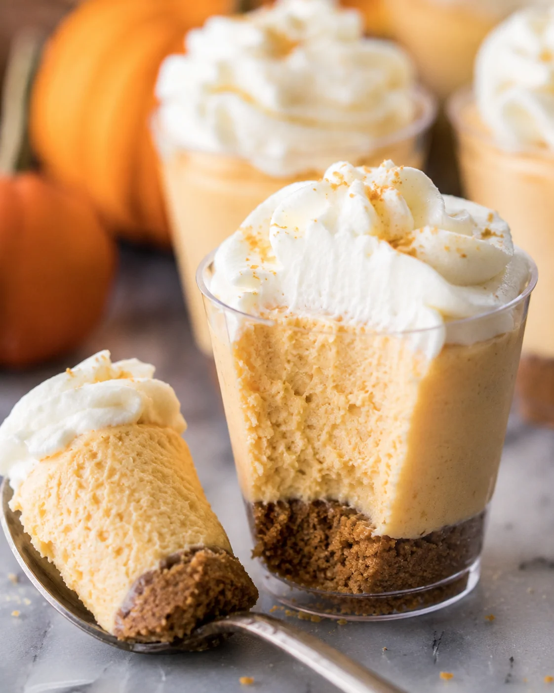 Delicious no-bake mini pumpkin pie cheesecakes with a crunchy crust and whipped topping.