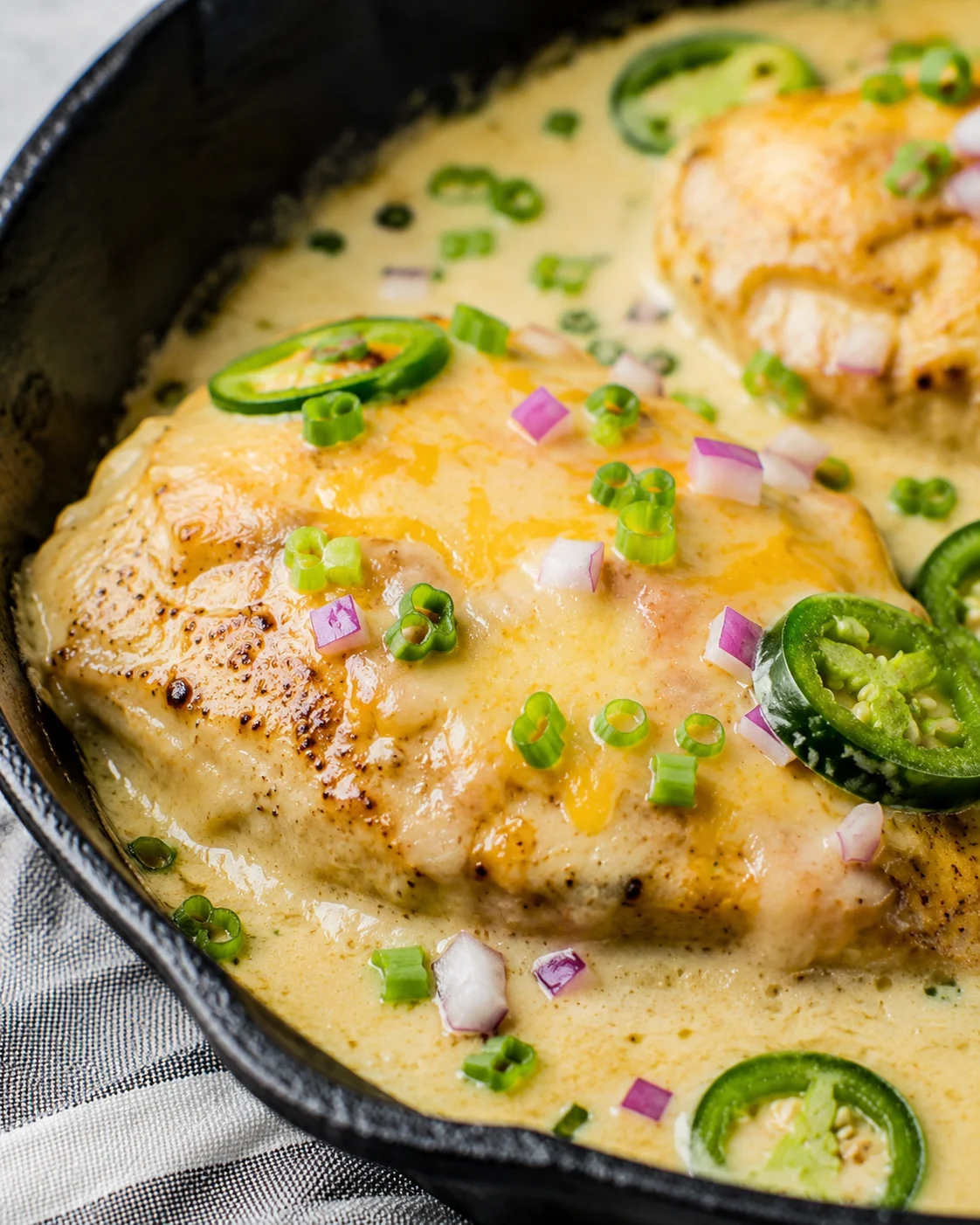 Creamy, cheesy keto chicken with jalapenos garnished with green onions.