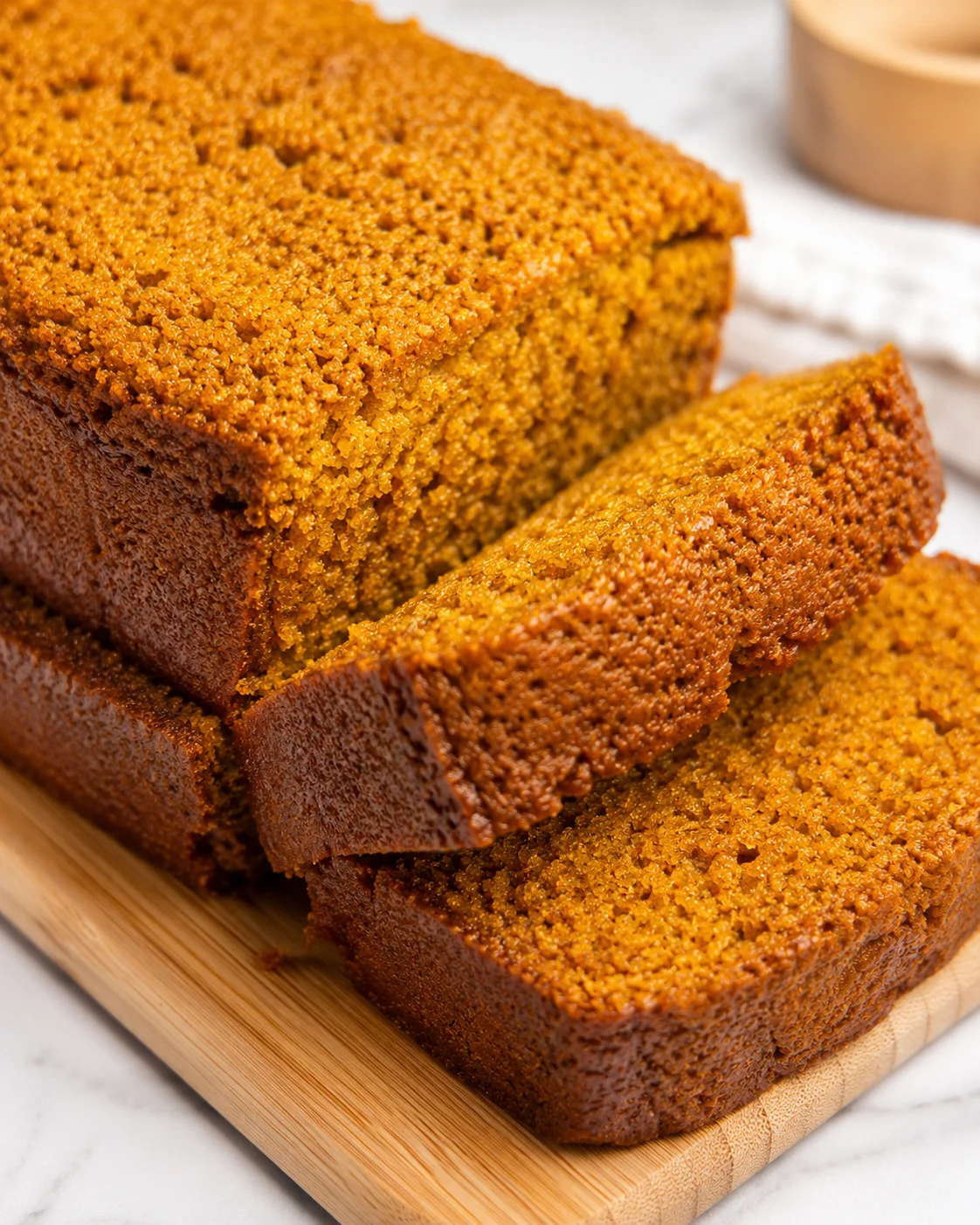 Freshly baked pumpkin bread, golden brown with a crumbly topping and moist texture.