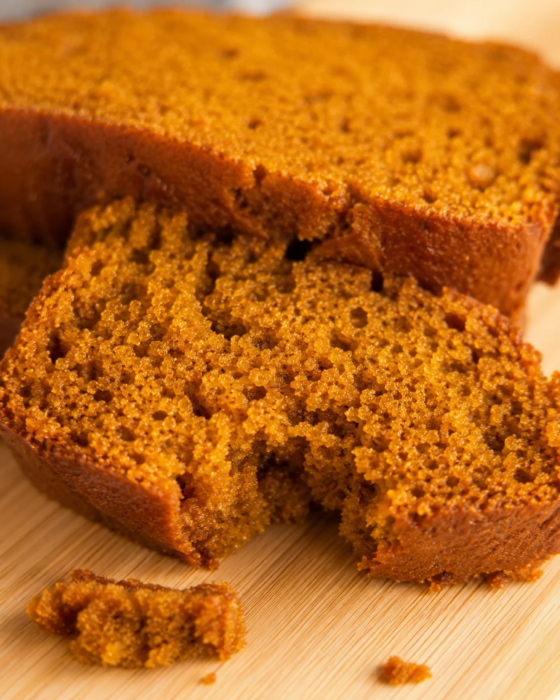 Freshly baked moist and spiced pumpkin bread on a wooden surface