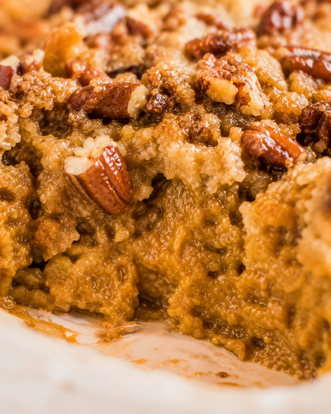 Close-up of a baked pumpkin dump cake with a crumbly topping and pecans