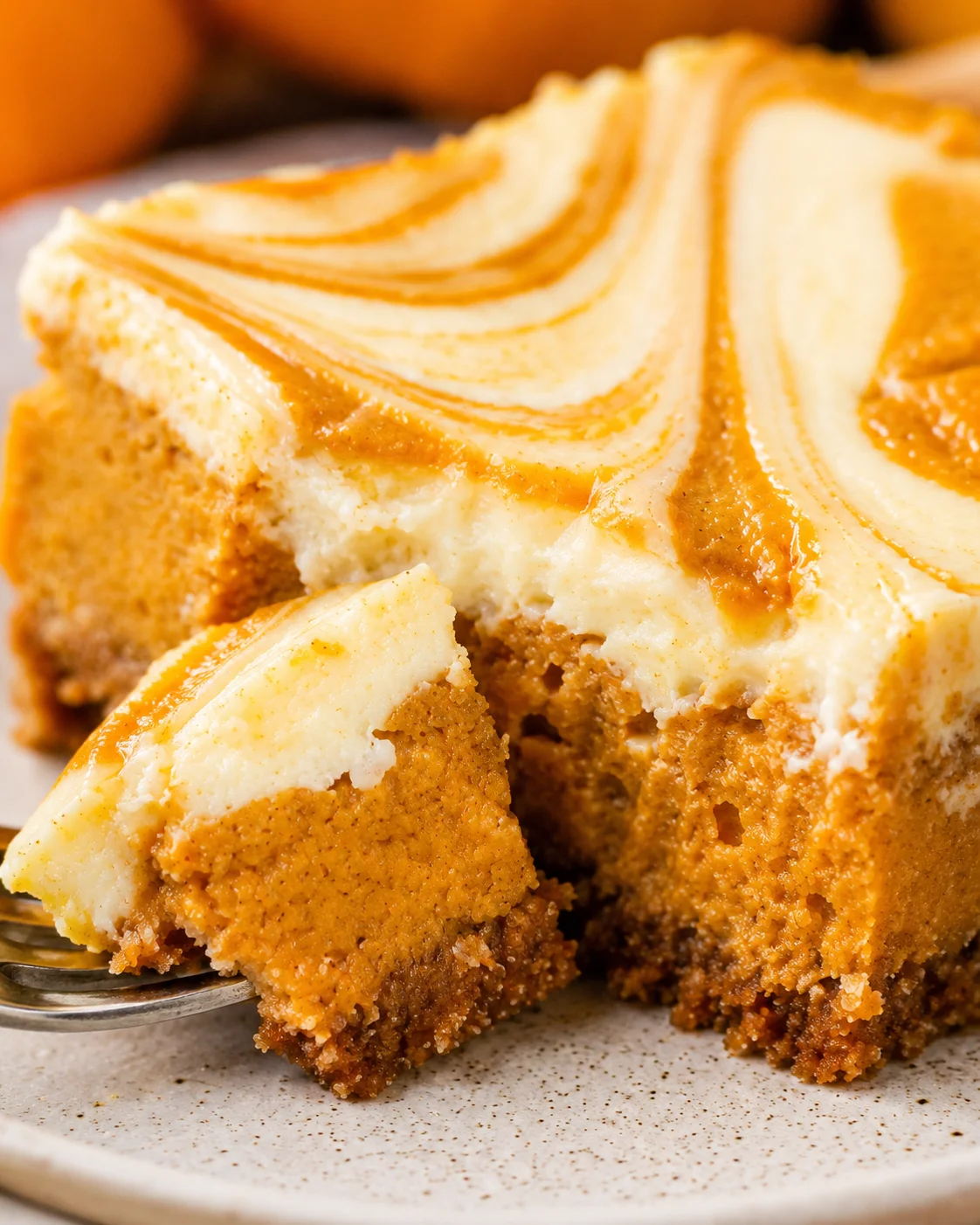Delicious swirled pumpkin cheesecake bars with marbled top and graham cracker crust.