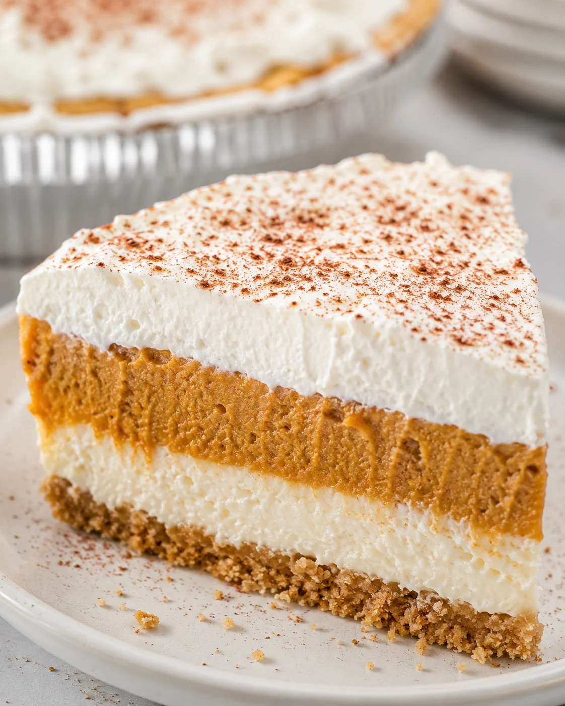 Slice of no bake pumpkin pie with a creamy pumpkin filling and whipped topping