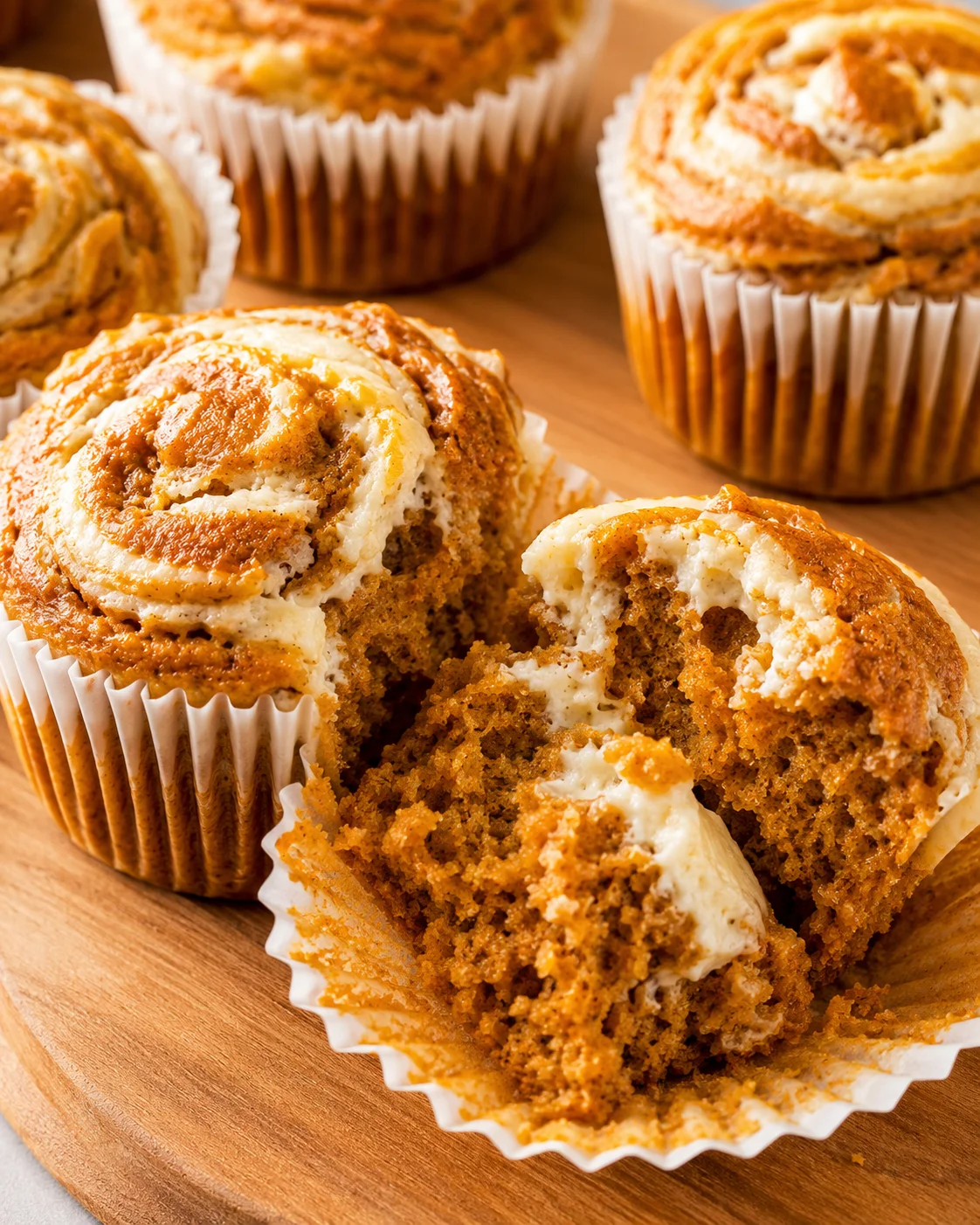 Moist pumpkin muffins with swirled cream cheese topping, perfect for fall treats.