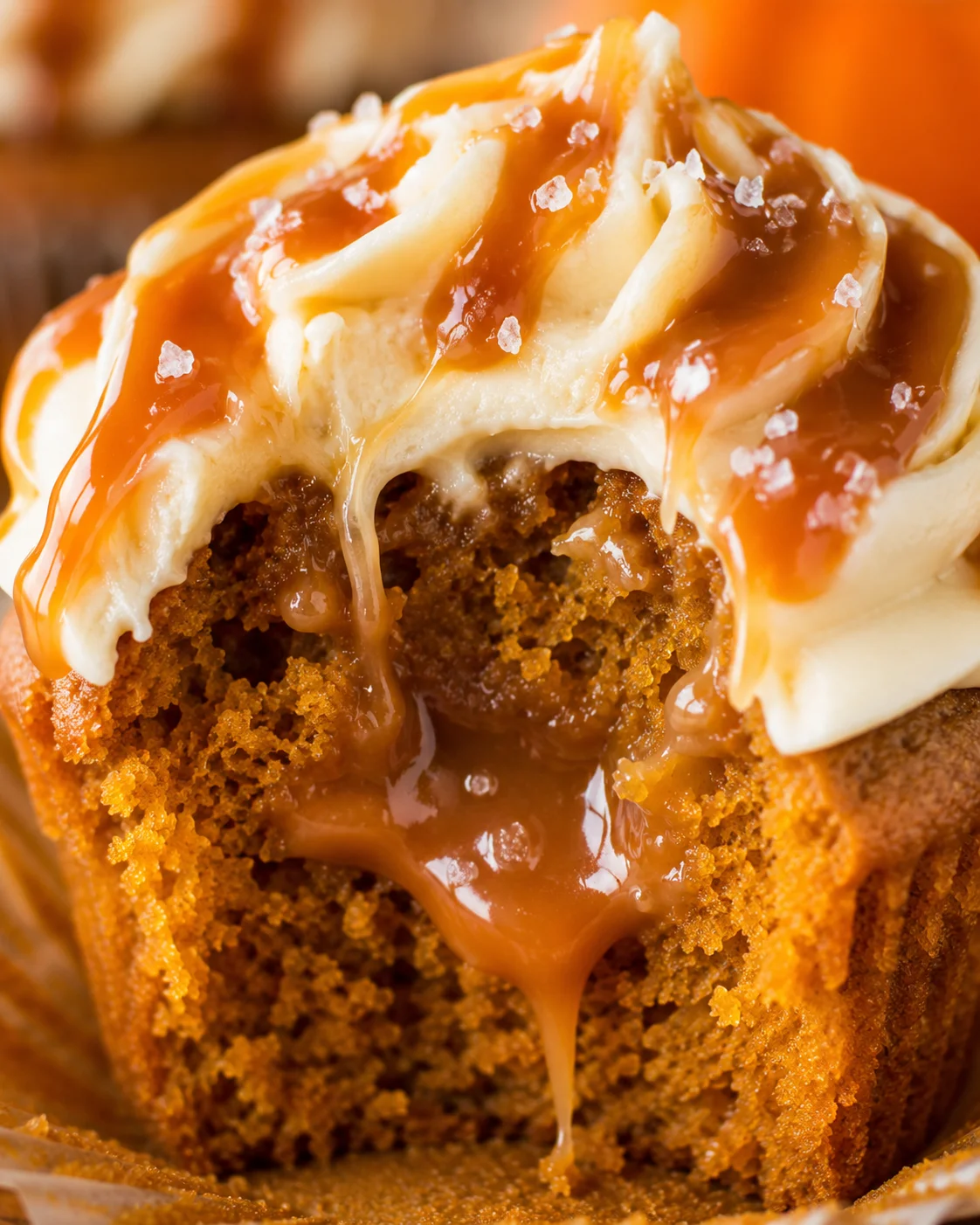 Close-up of moist pumpkin cupcake topped with salted caramel frosting and salt flakes