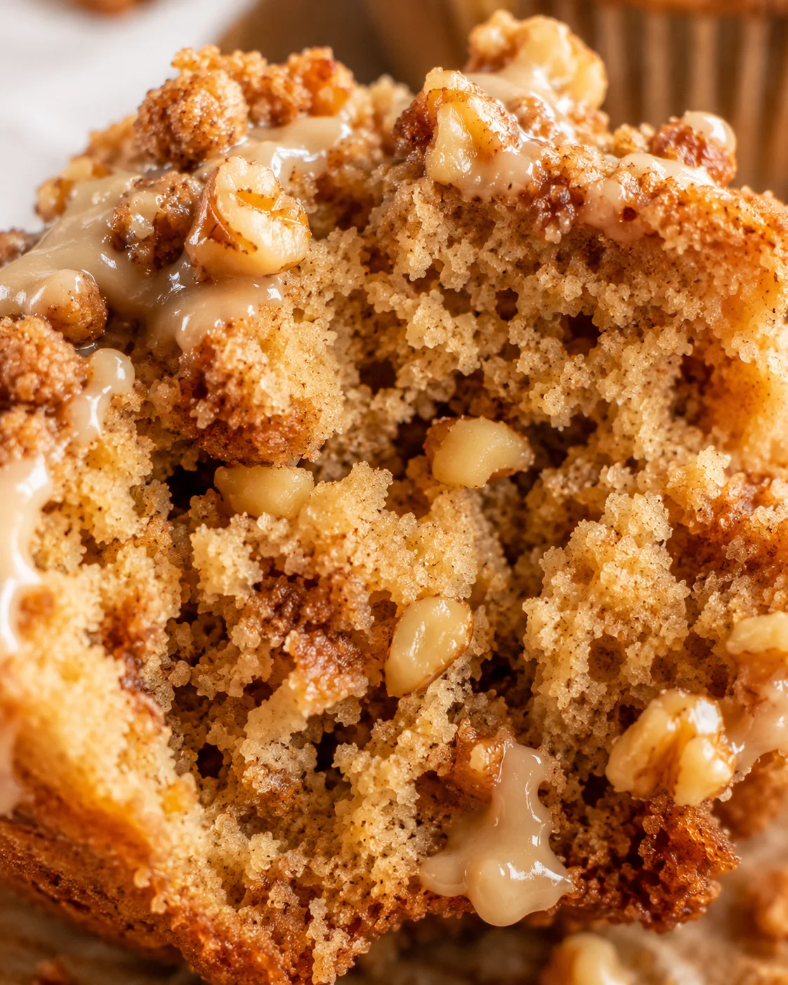 Close-up of a freshly baked maple walnut muffin with crunchy streusel topping.