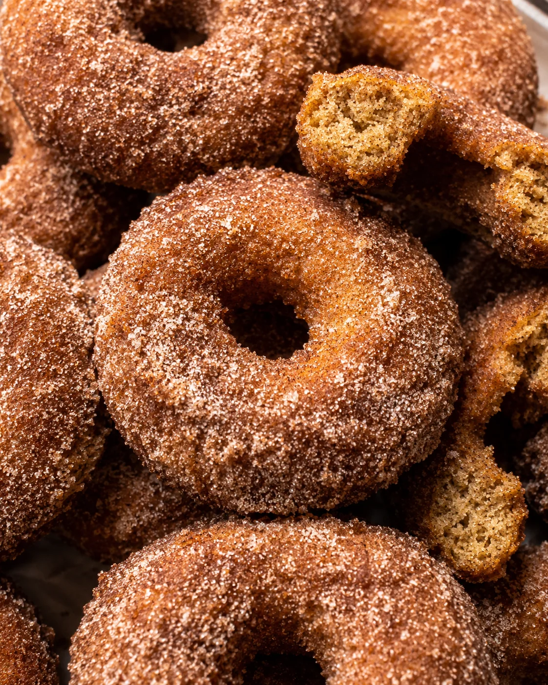 Close-up of golden baked apple cider donuts with cinnamon sugar coating.