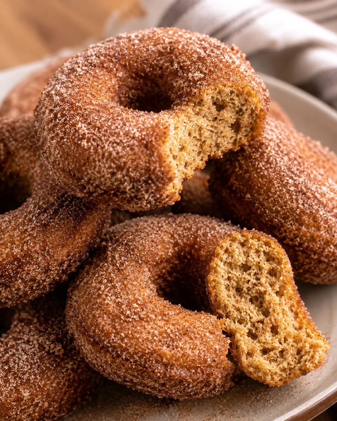 Close-up of baked apple cider donuts with sugar coating, showing moist interior.