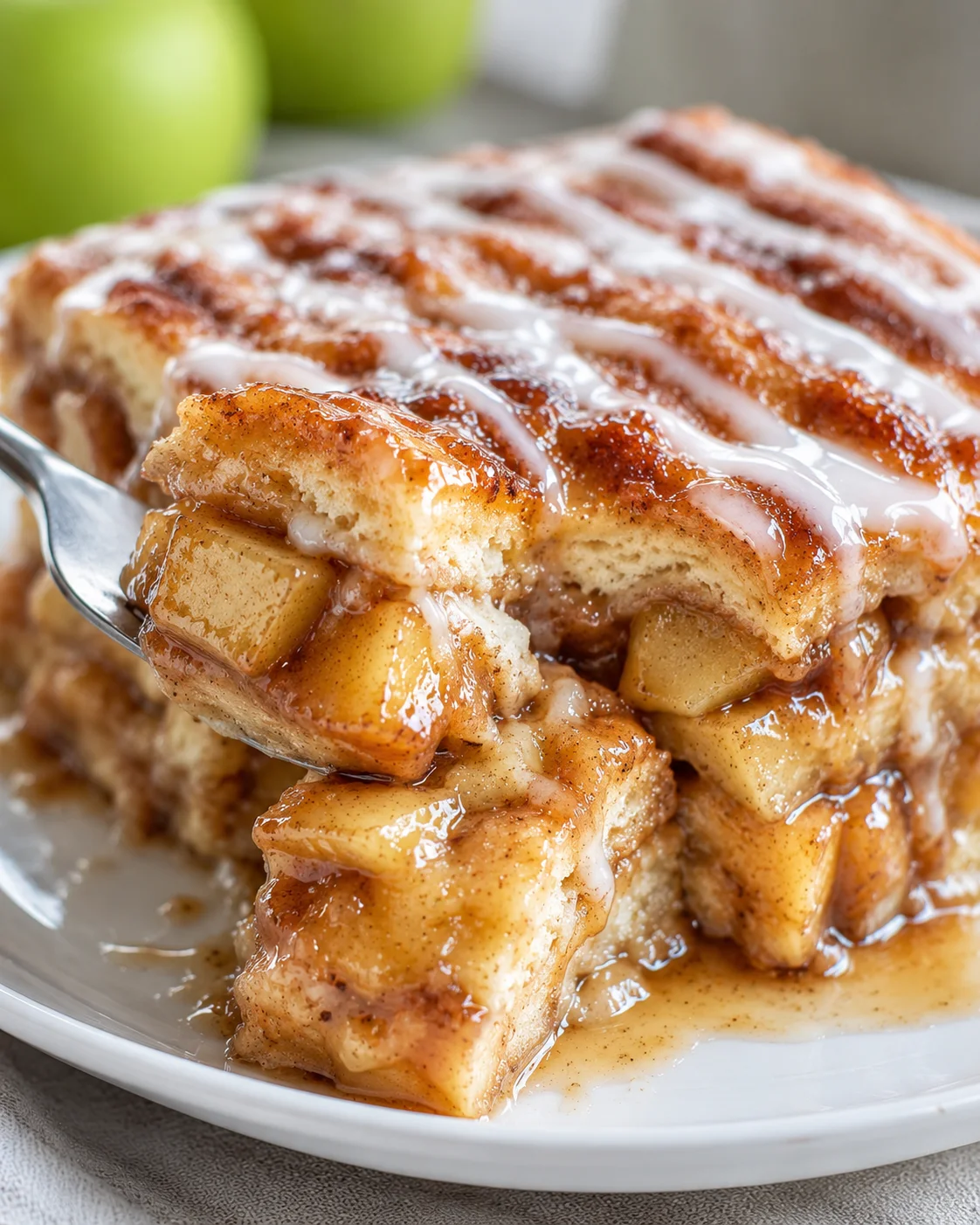 Close-up of layered caramel apple cinnamon roll lasagna with caramel sauce and apple filling.