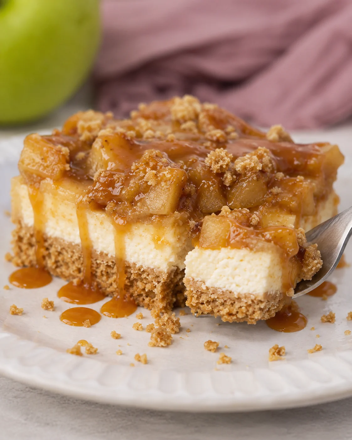 Delicious caramel apple cheesecake bars with streusel topping and caramel drizzle.