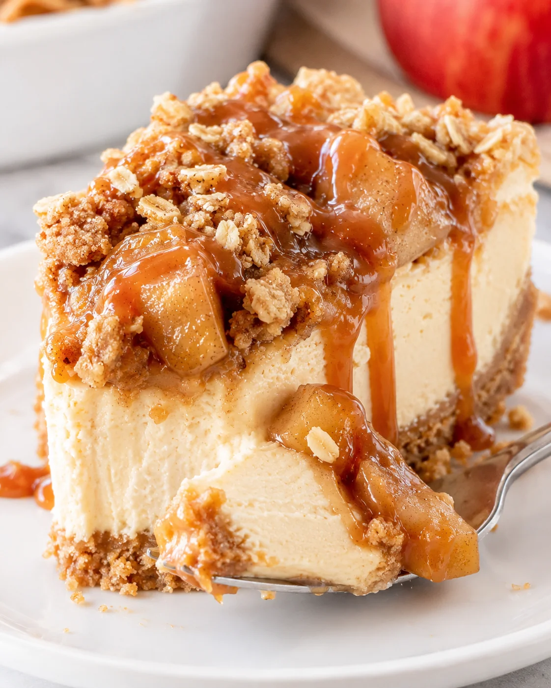 Delicious apple crisp cheesecake topped with caramel and crumble pieces