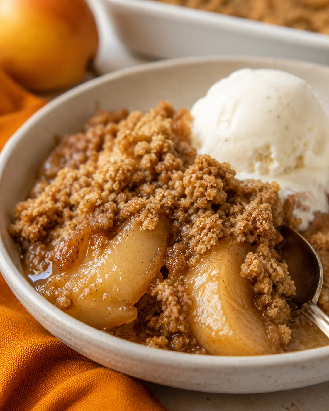 Close-up of warm pear crumble with vanilla ice cream on top