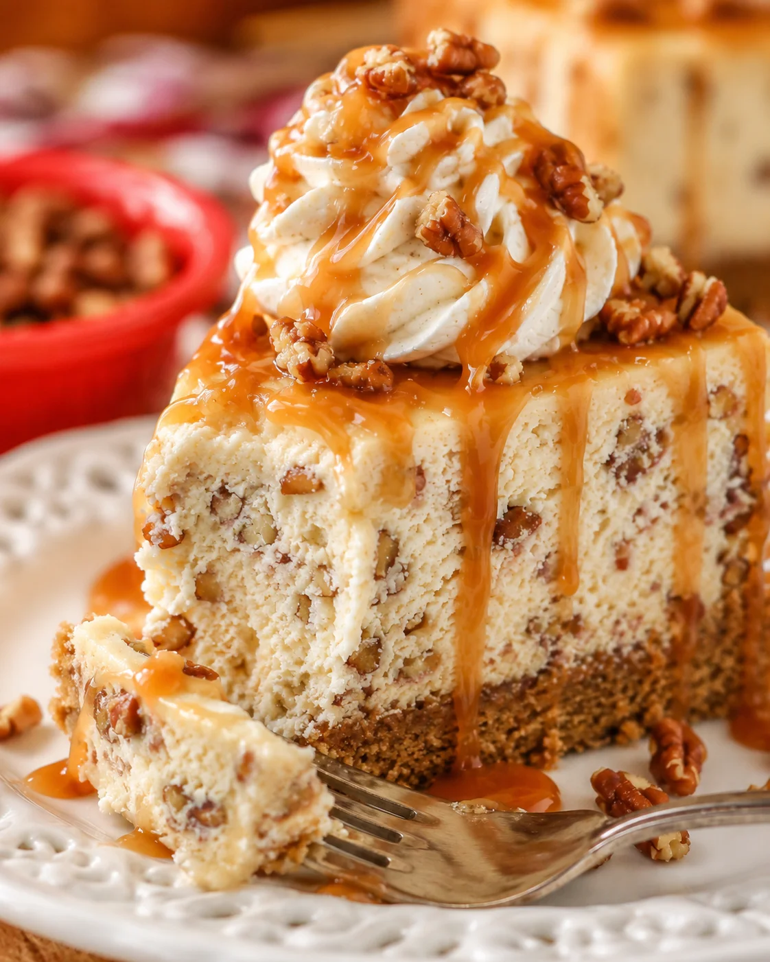 Delicious browned butter pecan cheesecake topped with whipped cream and caramel sauce.
