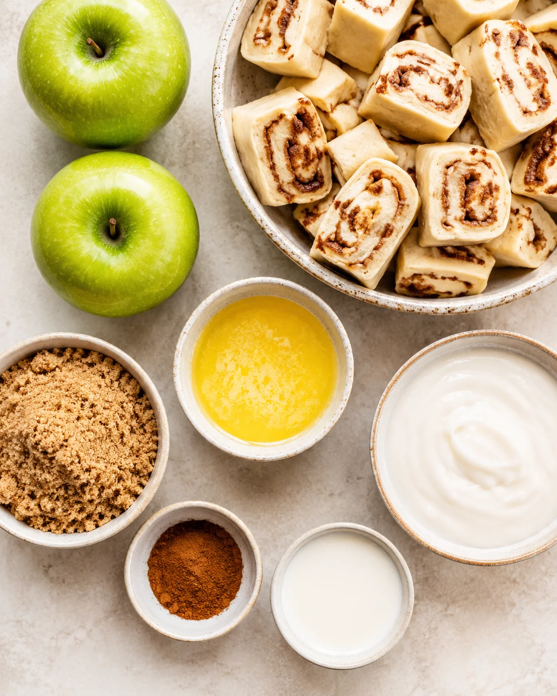 Fresh green apples and cinnamon rolls ready for baking in a cozy dish.
