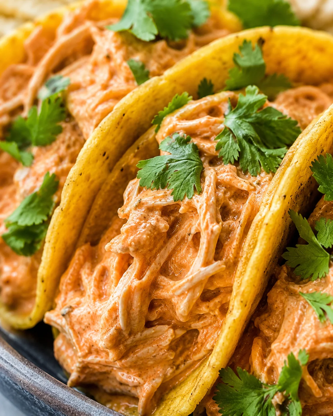 Delicious pulled chicken tacos topped with cilantro and salsa in soft tacos.