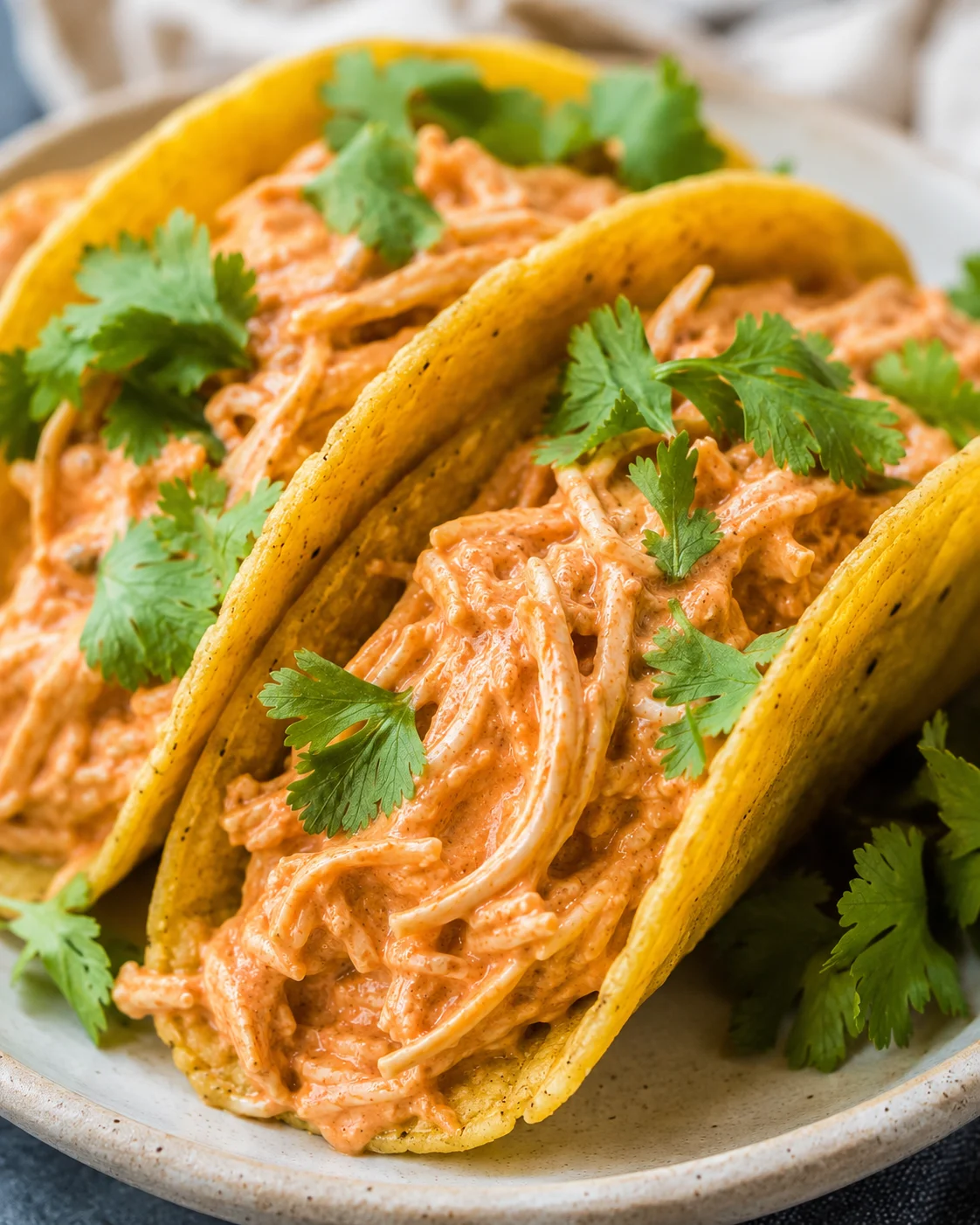 Delicious tacos filled with shredded chicken, salsa, and creamy topping garnished with cilantro