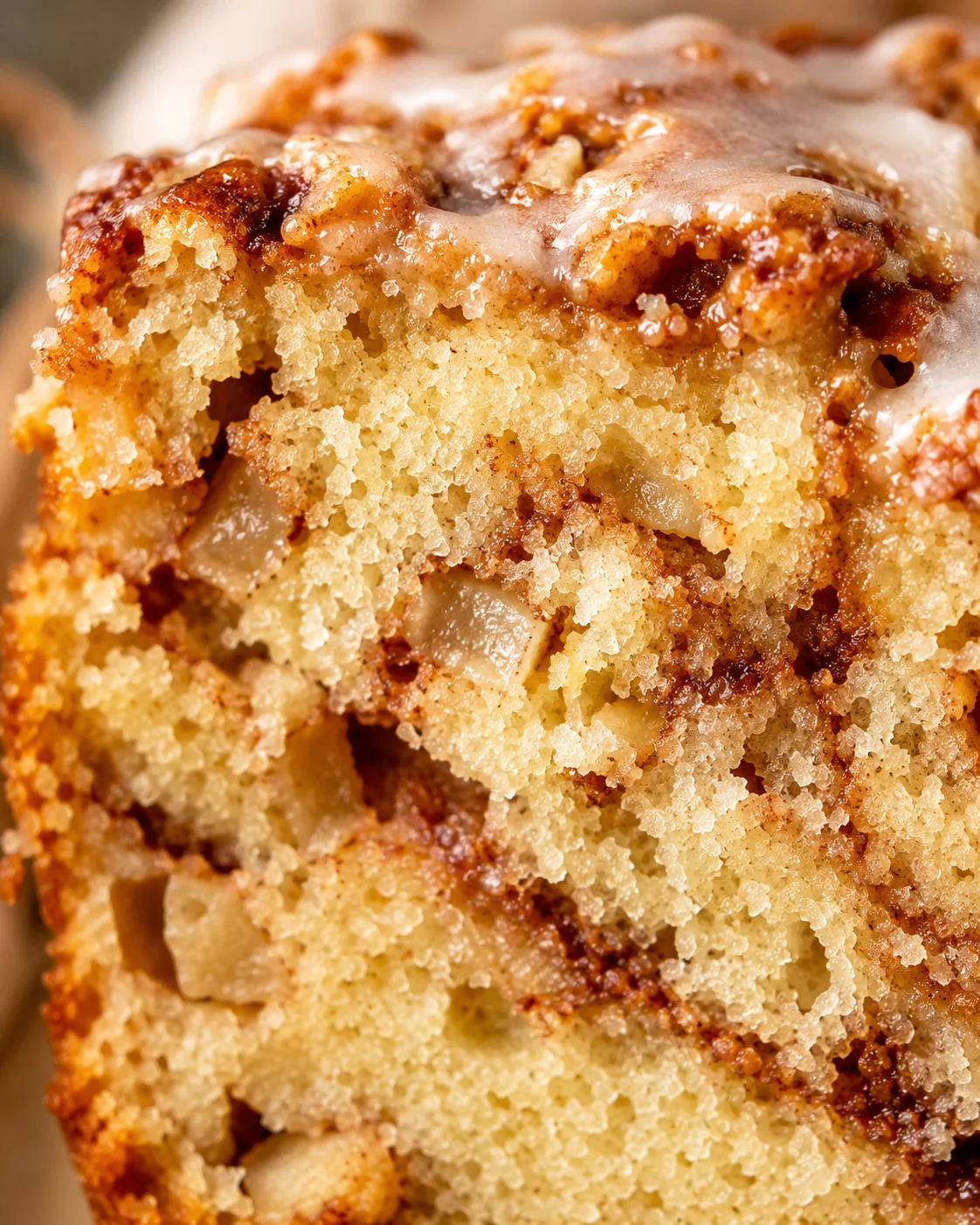 Close-up of moist cinnamon apple bread with swirl of brown sugar and apple chunks